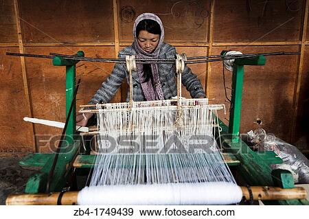 Stock Photo - Girl working at a loom weaving a carpet, Bumthang, Bhutan, Asia.. Fotosearch