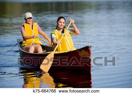 Girlfriends canoeing on lake View Large Photo Image Stock Photograph - Girlfriends canoeing on lake. Fotosearch