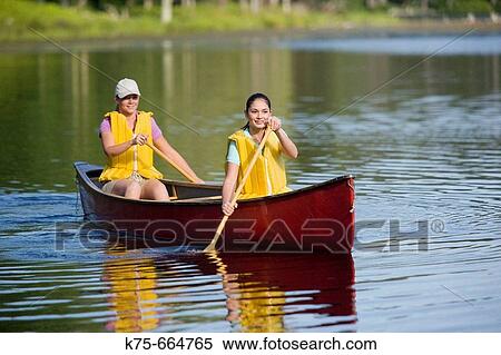 Girlfriends canoeing on lake View Large Photo Image Stock Photography - Girlfriends canoeing on lake. Fotosearch