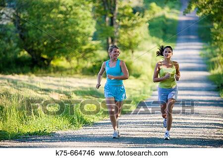 Girlfriends jogging together on country road View Large Photo Image Stock Photograph - Girlfriends jogging together on country road. Fotosearch