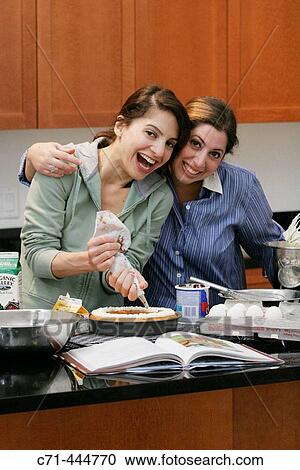 Girlfriends making cake View Large Photo Image Stock Image - Girlfriends making cake. Fotosearch
