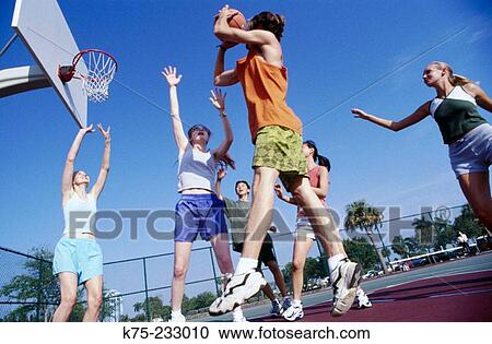 Stock Image - Girls and guys playing basketball. Fotosearch