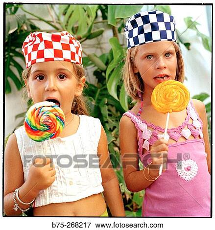 Girls eating lollipops View Large Photo Image Stock Photo - Girls eating lollipops. Fotosearch