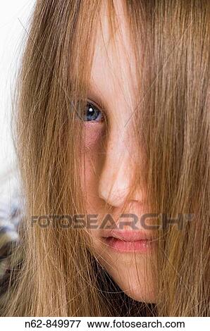 Stock Photo - Girls hidden by their blond hair smooth, leaving only see half the face. Fotosearch