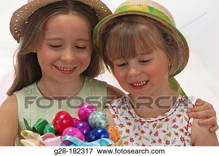 Girls looking at easter eggs View Large Photo Image Stock Photo - Girls looking at easter eggs. Fotosearch