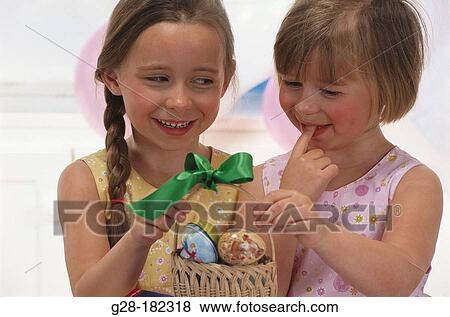 Girls looking at easter eggs View Large Photo Image Stock Photo - Girls looking at easter eggs. Fotosearch