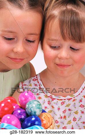 Girls looking at easter eggs View Large Photo Image Stock Photo - Girls looking at easter eggs. Fotosearch