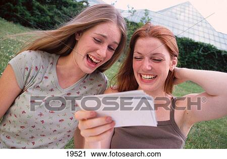 Girls looking at photos View Large Photo Image Stock Image - Girls looking at photos. Fotosearch