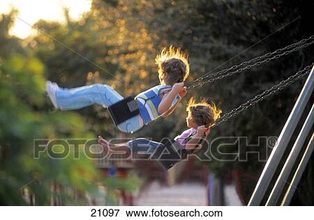 Girls on a swing in a playground View Large Photo Image Stock Photo - Girls on a swing in a playground. Fotosearch