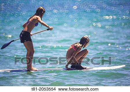 Girls on surfboard paddling in the Mediterranean Sea, Benicassim, Castellon province, Comunidad Valenciana, Spain View Large Photo Image Picture - Girls on surfboard paddling in the Mediterranean Sea, Benicassim, Castellon province, Comunidad Valenciana, Spain. Fotosearch