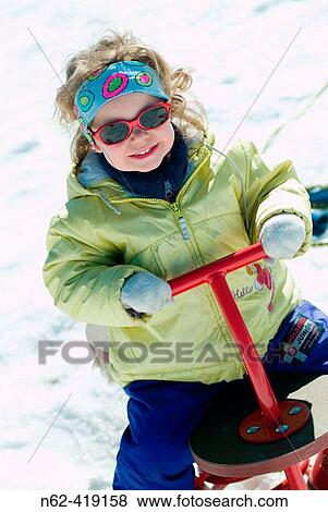 Girls playing on the playground swing in the snow View Large Photo Image Stock Photo - Girls playing on the playground swing in the snow. Fotosearch