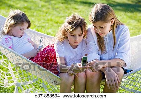 Girls with mobile phones outdoors View Large Photo Image Picture - Girls with mobile phones outdoors. Fotosearch