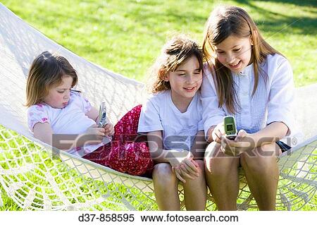 Girls with their mobile phone outdoors View Large Photo Image Stock Photography - Girls with their mobile phone outdoors. Fotosearch