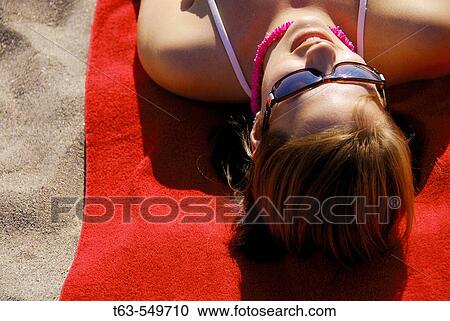girl/woman 20 yrs old suntanning on beach on red towel View Large Photo Image Stock Image - girl/woman 20 yrs old suntanning on beach on red towel. Fotosearch