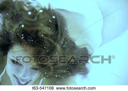 Girl/woman 20 yrs old swimming underwater smiling, swimming pool. View Large Photo Image Stock Photo - Girl/woman 20 yrs old swimming underwater smiling, swimming pool.. Fotosearch