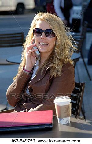 girl/woman 20 yrs on cell phone at cafe/coffee shop with coffee and laptop computer, sunglasses, city, urban, metropolitan, smiling, happy, street, traffic, talking, View Large Photo Image Stock Photo - girl/woman 20 yrs on cell phone at cafe/coffee shop with coffee and laptop computer, sunglasses, city, urban, metropolitan, smiling, happy, street, traffic, talking,. Fotosearch