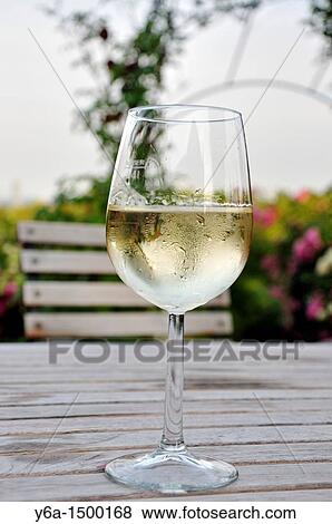 Stock Photo - Glass of white wine on wooden table in Heuriger Grinzing Vienna. Fotosearch