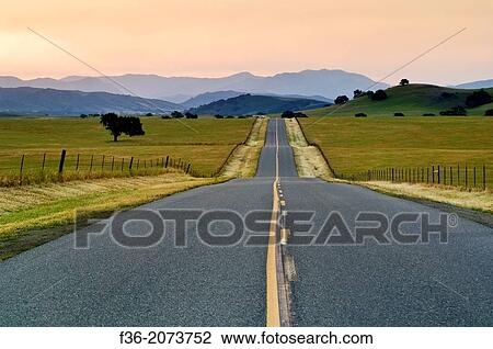 Golden sunrise light over long straight two lane country road and rolling hills in Spring, Santa Ynez Valley, California. View Large Photo Image Stock Image - Golden sunrise light over long straight two lane country road and rolling hills in Spring, Santa Ynez Valley, California.. Fotosearch