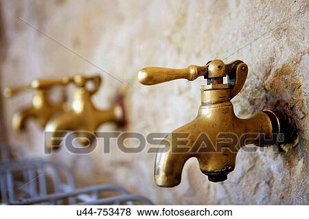Golden taps in a natural water source View Large Photo Image Stock Photo - Golden taps in a natural water source. Fotosearch