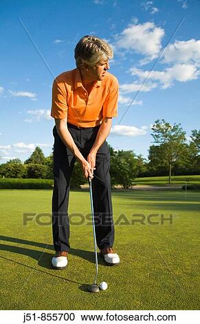 GOLF Adult middle aged male practice putting on green at public course in Deerfield, Illinois, address ball with putter View Large Photo Image Stock Image - GOLF Adult middle aged male practice putting on green at public course in Deerfield, Illinois, address ball with putter. Fotosearch