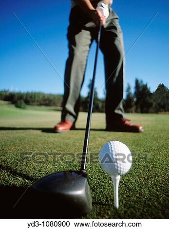 Golfer about to hit golf ball off of tee with driver, low angle View Large Photo Image Stock Image - Golfer about to hit golf ball off of tee with driver, low angle. Fotosearch