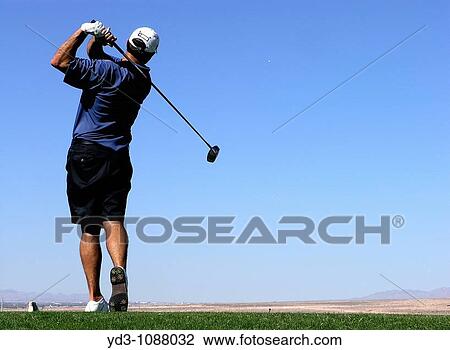 Golfer following through with swing after using driver to hit ball, ball and blue sky in background View Large Photo Image Stock Image - Golfer following through with swing after using driver to hit ball, ball and blue sky in background. Fotosearch