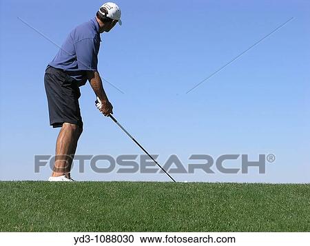 Golfer looking at target addressing ball with driver, blue sky in background View Large Photo Image Stock Image - Golfer looking at target addressing ball with driver, blue sky in background. Fotosearch