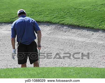 Golfer raking sand trap after hitting ball out, rear view View Large Photo Image Stock Photo - Golfer raking sand trap after hitting ball out, rear view. Fotosearch