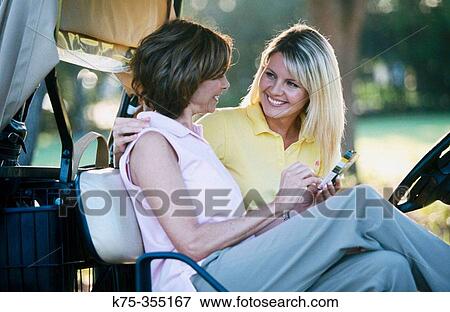 Stock Photo - Golfing mother and daughter writing the scorecard. Fotosearch