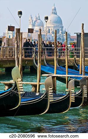 Gondolas, in the foreground and tourists in front of Salute Church, in the background, Venice, Italy. View Large Photo Image Stock Photograph - Gondolas, in the foreground and tourists in front of Salute Church, in the background, Venice, Italy.. Fotosearch