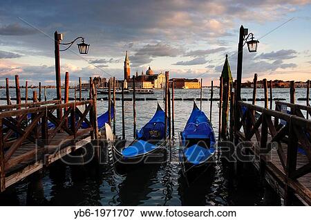 Gondolas moored at Venice waterfront with San Giorgio Maggiore in the background, Italy. View Large Photo Image Stock Photo - Gondolas moored at Venice waterfront with San Giorgio Maggiore in the background, Italy.. Fotosearch