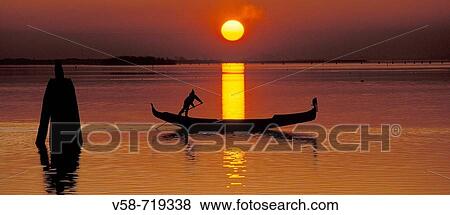 Stock Photo - Gondolier at sunset. Venice lagoon. Italy. Fotosearch