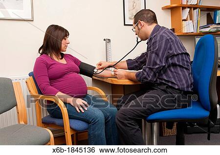 GP Doctor checking pregnant woman blood pressure View Large Photo Image Stock Photograph - GP Doctor checking pregnant woman blood pressure. Fotosearch