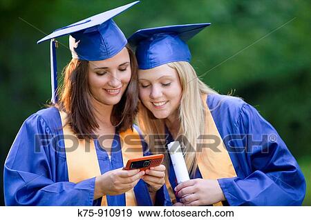 Graduates text message friends View Large Photo Image Stock Photo - Graduates text message friends. Fotosearch