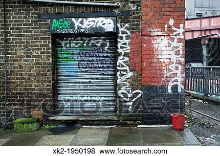 Graffity and a red bucket in front of a metal door, London, UK View Large Photo Image Stock Photo - Graffity and a red bucket in front of a metal door, London, UK. Fotosearch