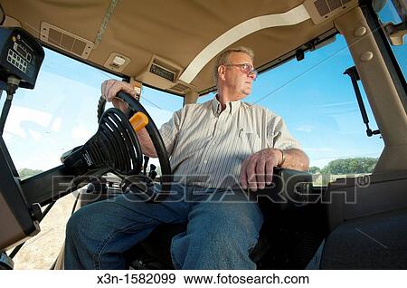 Stock Photo - Grain producer operating tractor planting soybeans, Montgomery County Maryland USA. Fotosearch
