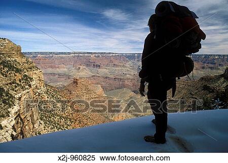 Stock Photography - Grand Canyon National Park - Martha Gruelle backpacking in snow near the top of the Bright Angel Trail in the Grand Canyon Temperatures can be as much as 30 degrees F warmer at the bottom of the canyon MR. Fotosearch
