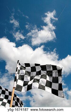 grand prix chequered flags flying in wind and blue sky View Large Photo Image Stock Photo - grand prix chequered flags flying in wind and blue sky. Fotosearch