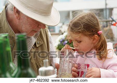 Grandad helping his 3 year old grandaughter with her drink in an outside caf? View Large Photo Image Stock Image - Grandad helping his 3 year old grandaughter with her drink in an outside caf?. Fotosearch
