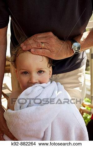 Grandfather affectionately putting his hand on grandson. View Large Photo Image Picture - Grandfather affectionately putting his hand on grandson.. Fotosearch