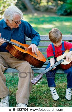 Grandfather and grandchild practicing guitar View Large Photo Image Picture - Grandfather and grandchild practicing guitar. Fotosearch