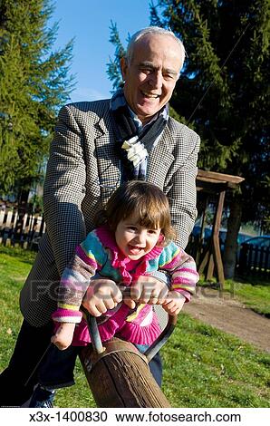 Grandfather and granddaughter on a seesaw View Large Photo Image Stock Image - Grandfather and granddaughter on a seesaw. Fotosearch