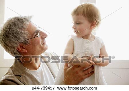 Stock Photo - Grandfather holding his granddaughter. Fotosearch