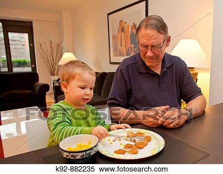 Grandfather watching grandson eat dinner. View Large Photo Image Stock Photography - Grandfather watching grandson eat dinner.. Fotosearch