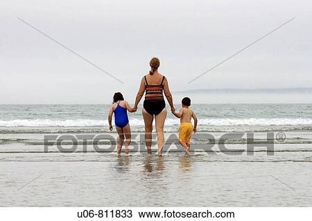 grandmother and two kids walking into the surf at the beach hand in hand View Large Photo Image Stock Image - grandmother and two kids walking into the surf at the beach hand in hand. Fotosearch