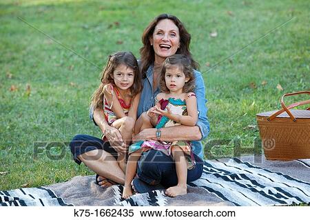 Stock Photography - Grandmother holding her two granddaughters in her lap. Fotosearch