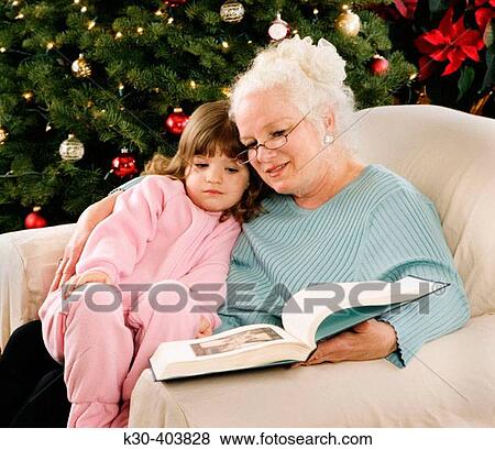 Grandmother reading to child at Christmas. View Large Photo Image Stock Photo - Grandmother reading to child at Christmas.. Fotosearch