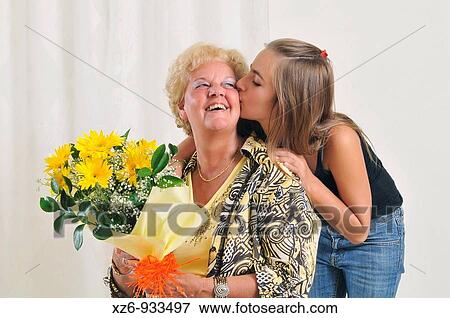Grandmother receiving flowers from granddaughter View Large Photo Image Stock Photo - Grandmother receiving flowers from granddaughter. Fotosearch