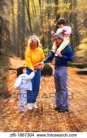 Picture - Grandparents take their granddaughters on a nature walk to enjoy the beautiful fall colors. Fotosearch