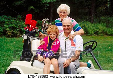 Stock Image - Grandparents with 10 year old at golf course. Fotosearch